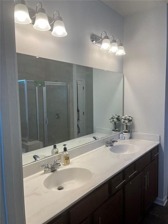 full bath with a sink, double vanity, and a stall shower