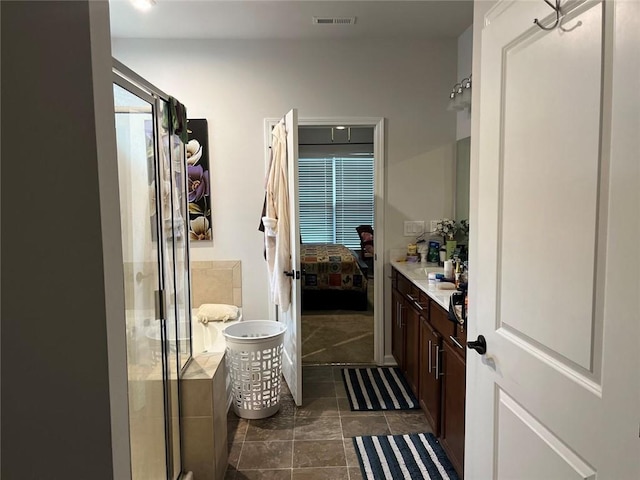 ensuite bathroom featuring a stall shower, ensuite bathroom, visible vents, tile patterned floors, and vanity