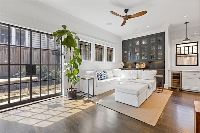 living room featuring beverage cooler, ornamental molding, recessed lighting, ceiling fan, and dark wood-style flooring