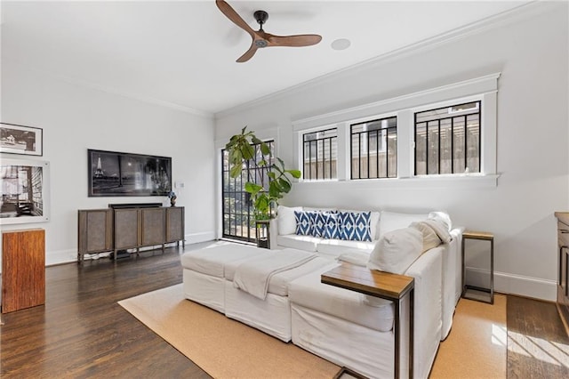 living room with crown molding, wood finished floors, baseboards, and ceiling fan