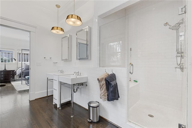 bathroom with baseboards, wood finished floors, a shower stall, and crown molding