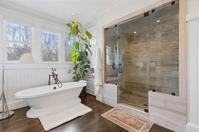 full bath with ornamental molding, wood finished floors, a stall shower, and a freestanding bath