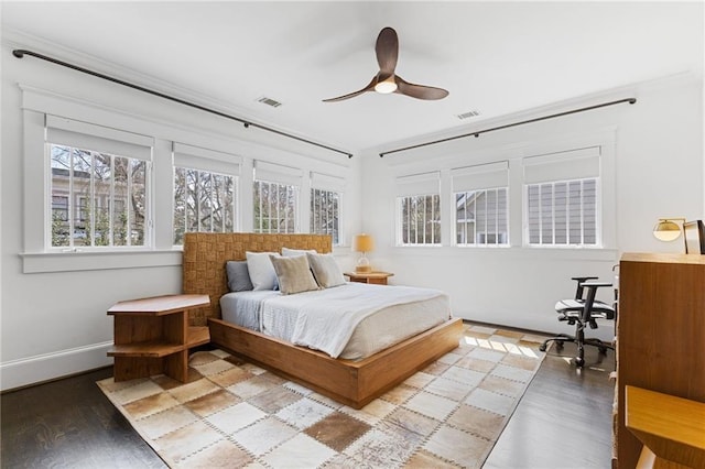 bedroom with visible vents, baseboards, wood finished floors, and a ceiling fan