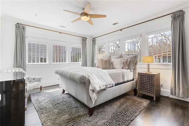 bedroom featuring visible vents, a ceiling fan, baseboards, and wood finished floors