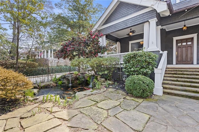 property entrance with a porch and fence