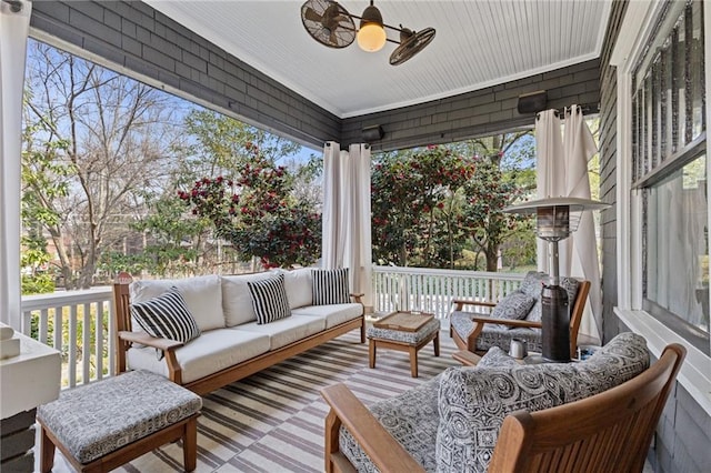 wooden deck featuring an outdoor living space and ceiling fan