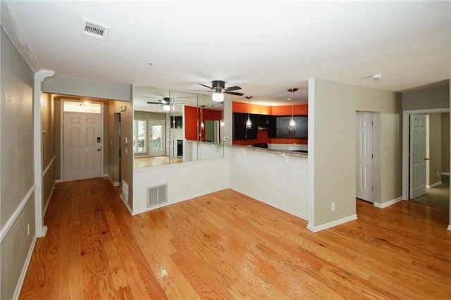 485 Sherman Way, Decatur, GA 30033 - kitchen with ceiling fan, light wood-style flooring, a peninsula, baseboards, and a breakfast bar