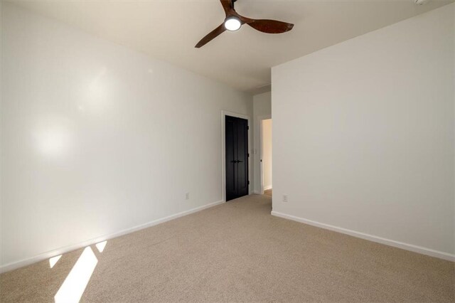 unfurnished room featuring light carpet and ceiling fan