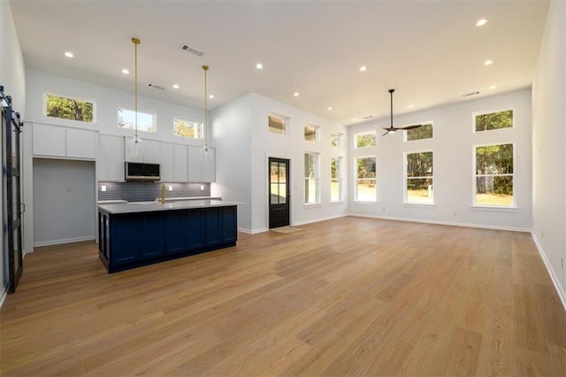 kitchen featuring white cabinetry, a wealth of natural light, and hanging light fixtures