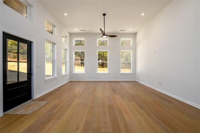 unfurnished sunroom with ceiling fan