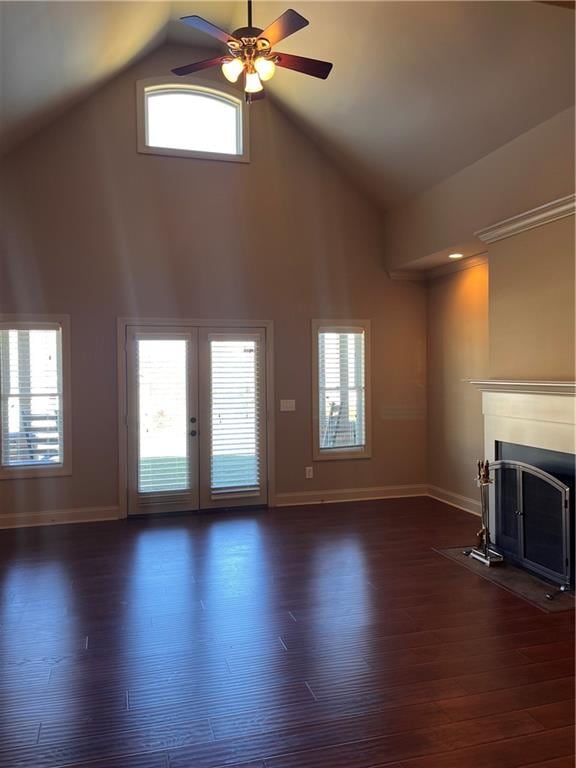 unfurnished living room with dark wood-type flooring, high vaulted ceiling, and a healthy amount of sunlight