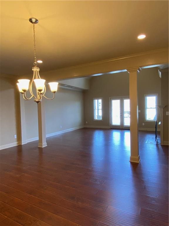 spare room with dark hardwood / wood-style flooring, ornamental molding, and a chandelier