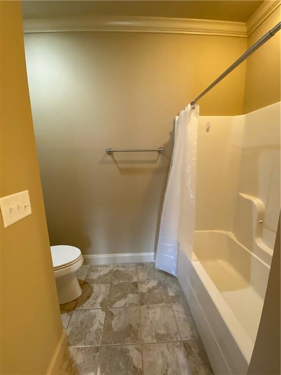 carpeted empty room with ceiling fan and crown molding