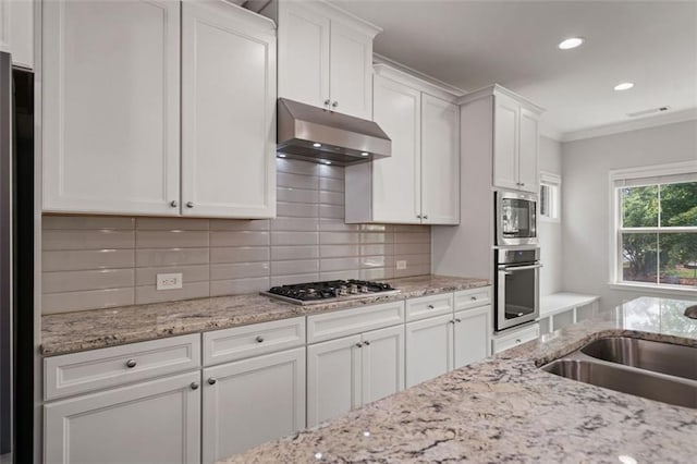 1463 Edgebrook Ct NE Unit 14, Atlanta, GA 30329 - kitchen with stainless steel appliances, under cabinet range hood, white cabinets, tasteful backsplash, and crown molding