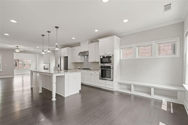 1463 Edgebrook Ct NE Unit 14, Atlanta, GA 30329 - kitchen featuring stainless steel refrigerator with ice dispenser, under cabinet range hood, recessed lighting, a center island with sink, and decorative backsplash