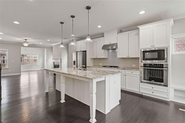 1463 Edgebrook Ct NE Unit 14, Atlanta, GA 30329 - kitchen with appliances with stainless steel finishes, under cabinet range hood, recessed lighting, an island with sink, and dark wood-style flooring