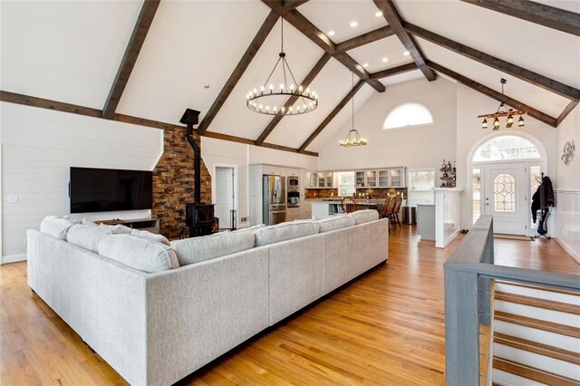 2600 Ramsey Rd, Gainesville, GA 30501 - living room with an inviting chandelier, high vaulted ceiling, a wood stove, and light wood-type flooring