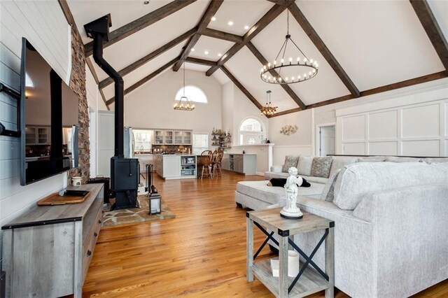 2600 Ramsey Rd, Gainesville, GA 30501 - living room with light hardwood / wood-style flooring, beam ceiling, high vaulted ceiling, a chandelier, and a wood stove