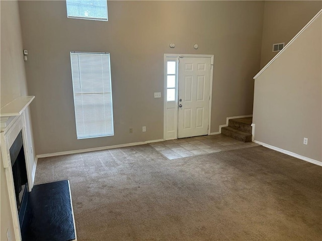 4963 Windsor Downs Ln, Decatur, GA 30035 - carpeted entrance foyer with a high ceiling, stairs, baseboards, and a fireplace