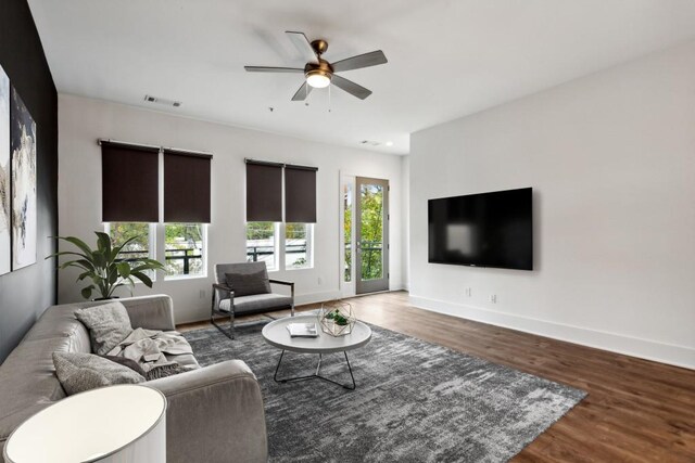 living room featuring ceiling fan and dark wood-type flooring