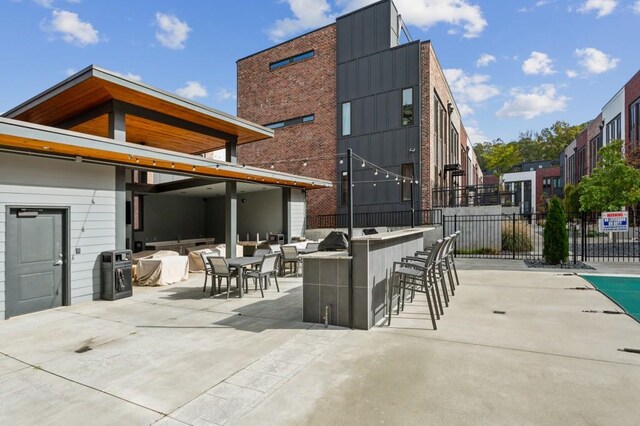 view of patio featuring exterior bar and an outdoor kitchen