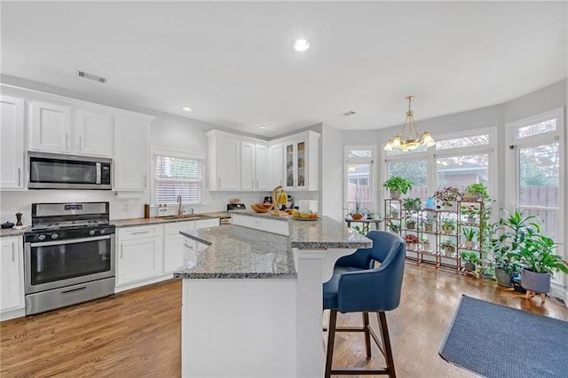 kitchen with a kitchen island, white cabinetry, and appliances with stainless steel finishes