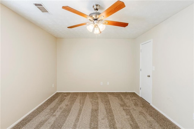 empty room with visible vents, baseboards, carpet, and a ceiling fan