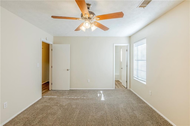 unfurnished room featuring a ceiling fan, baseboards, visible vents, a textured ceiling, and carpet flooring