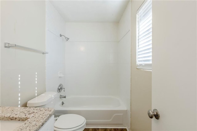 bathroom with tub / shower combination, toilet, and vanity