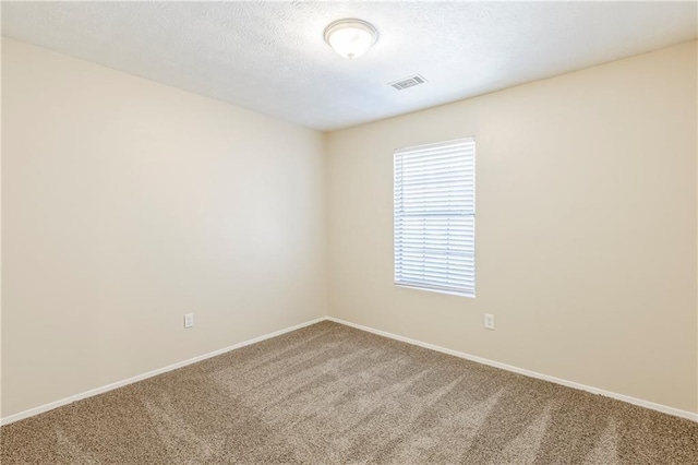 unfurnished room featuring visible vents, a textured ceiling, baseboards, and carpet floors