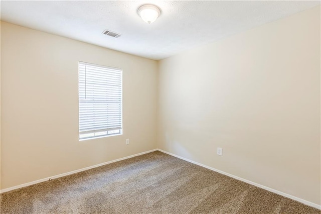 carpeted empty room with baseboards and visible vents