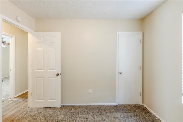 unfurnished bedroom with baseboards and light carpet