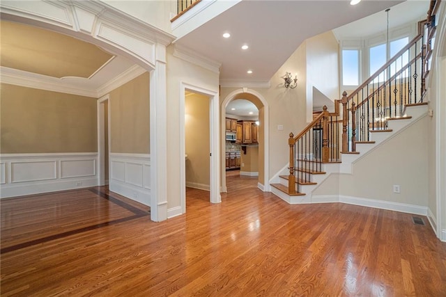 entrance foyer with ornamental molding and wood-type flooring