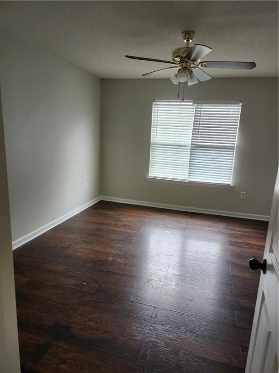 empty room featuring a ceiling fan, a textured ceiling, baseboards, and dark wood finished floors
