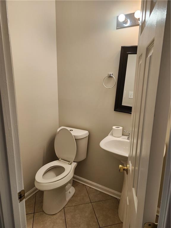 bathroom featuring tile patterned floors, baseboards, and toilet