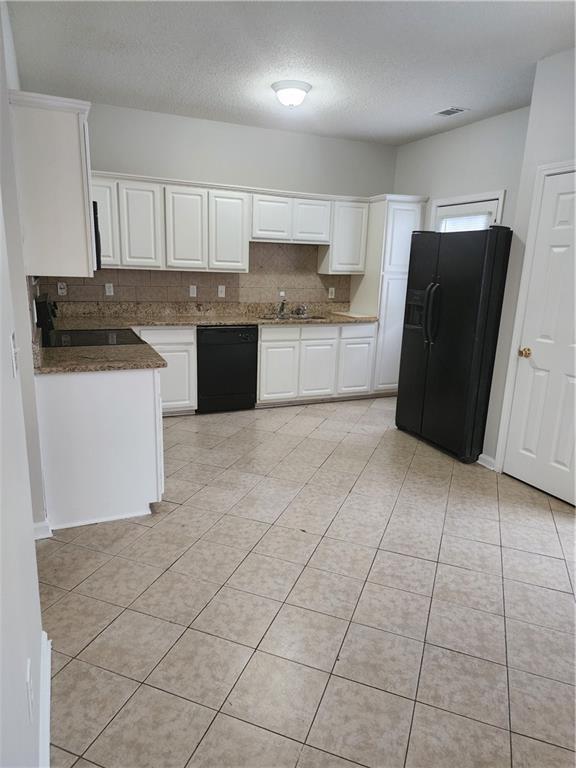 kitchen with tasteful backsplash, light tile patterned flooring, white cabinetry, and black appliances