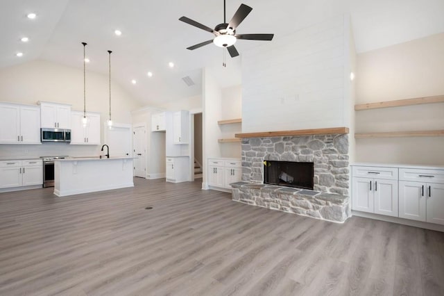 150 Doris Path, Dallas, GA 30157 - unfurnished living room featuring high vaulted ceiling, a ceiling fan, light wood finished floors, a stone fireplace, and baseboards