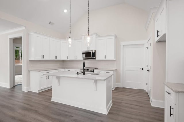 150 Doris Path, Dallas, GA 30157 - kitchen featuring stainless steel microwave, backsplash, white cabinets, a kitchen island with sink, and lofted ceiling