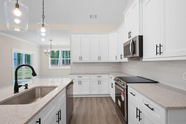 150 Doris Path, Dallas, GA 30157 - kitchen with stainless steel appliances, a sink, white cabinets, ornamental molding, and pendant lighting