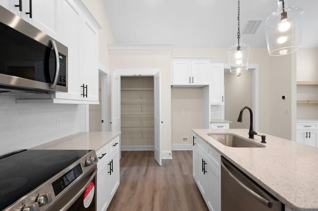 150 Doris Path, Dallas, GA 30157 - kitchen with appliances with stainless steel finishes, a sink, light wood finished floors, white cabinetry, and hanging light fixtures