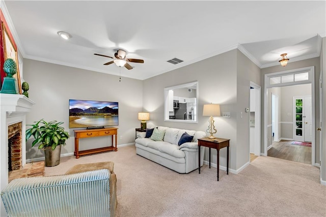 living area featuring baseboards, a fireplace, visible vents, and light colored carpet