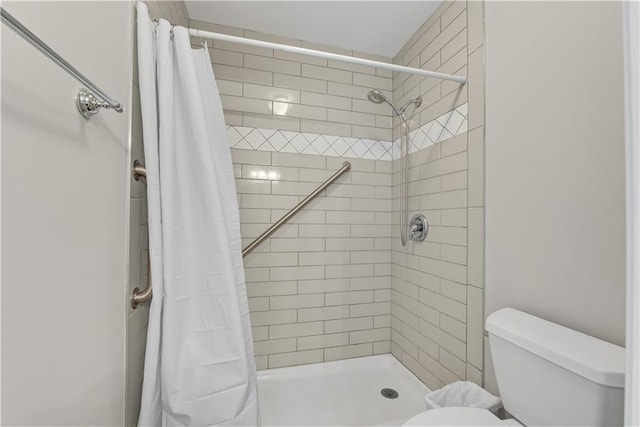 full bath featuring tiled shower and toilet