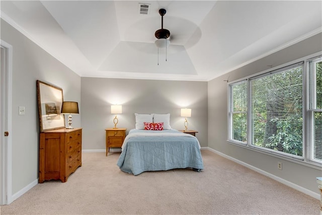 bedroom with baseboards, a tray ceiling, and light colored carpet