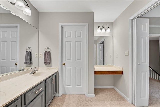 bathroom with double vanity, carpet, a sink, and baseboards