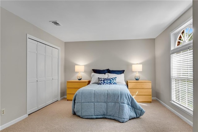 bedroom featuring carpet, baseboards, visible vents, and a closet