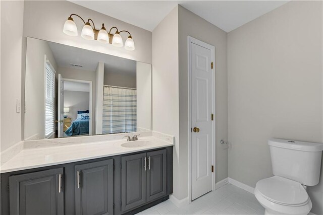 ensuite bathroom featuring baseboards, ensuite bathroom, a closet, and vanity