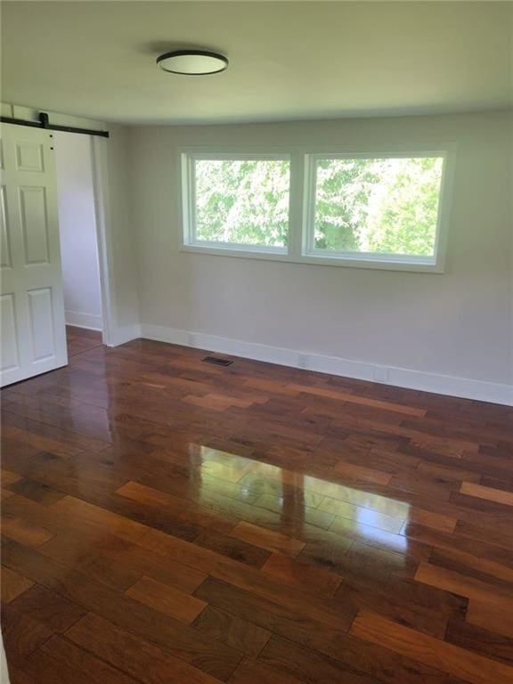 747 Bowman St, Macon, GA 31217 - empty room featuring a barn door and dark wood-style floors