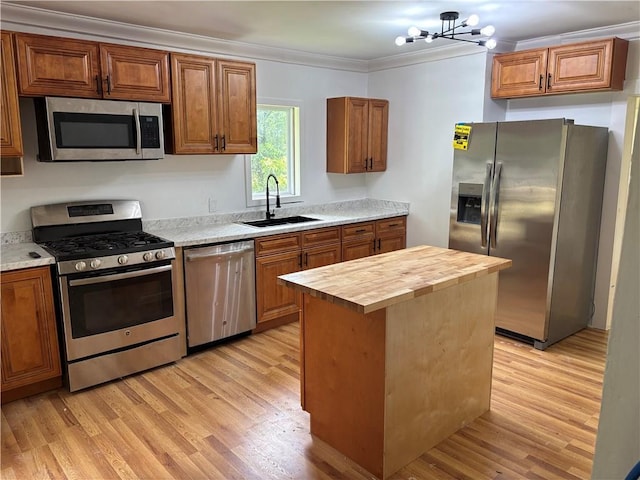 747 Bowman St, Macon, GA 31217 - kitchen featuring appliances with stainless steel finishes, wood counters, light wood finished floors, ornamental molding, and a chandelier