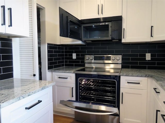 kitchen featuring light stone countertops, backsplash, white cabinetry, and stainless steel electric range