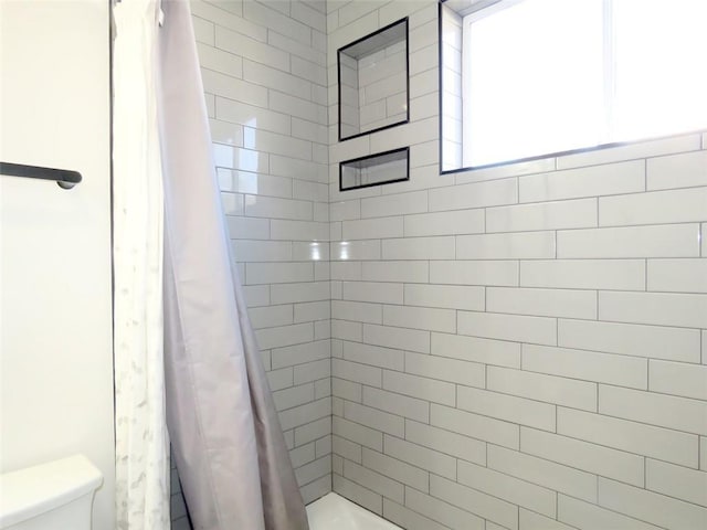 bathroom with shower / bathtub combination with curtain and toilet